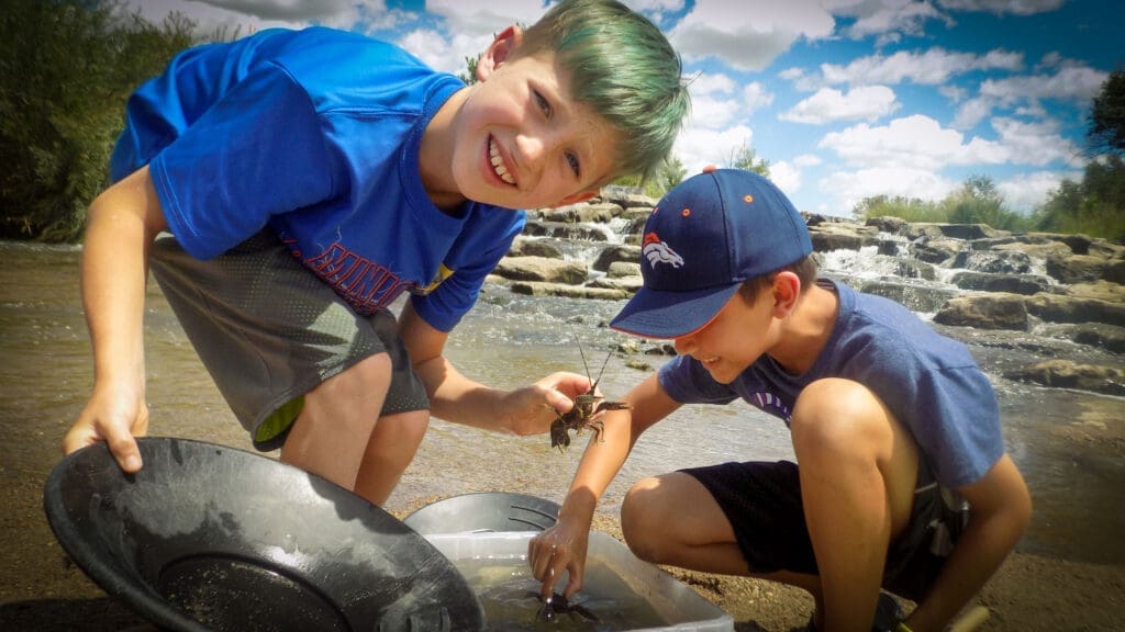 SPREE campers show off crawfish they caught in the South Platte River